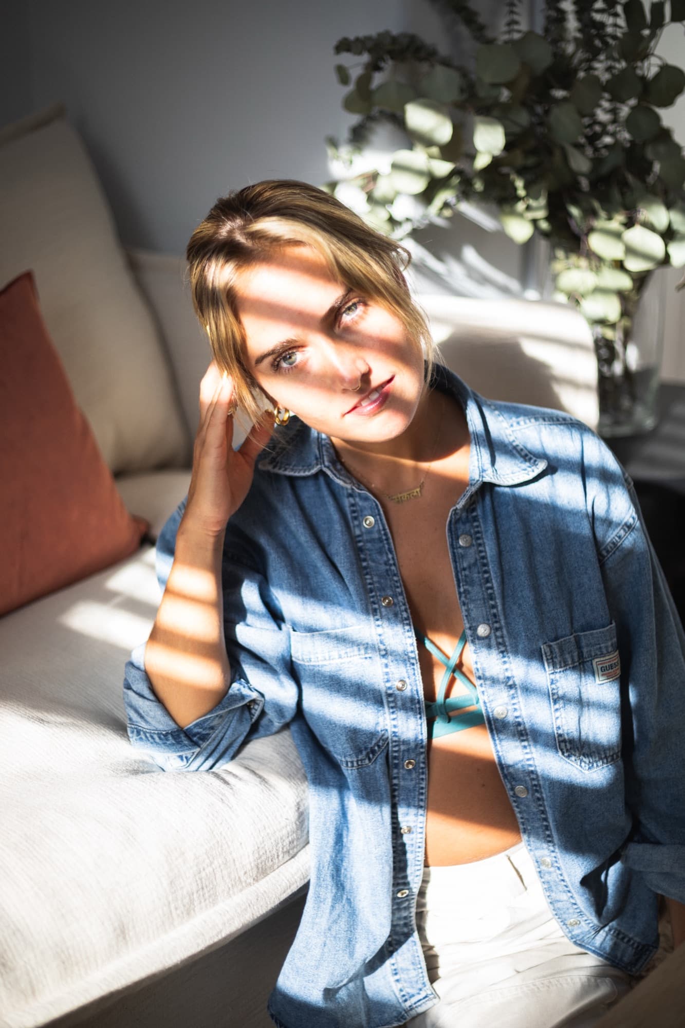 Portrait of a woman seated by a window with bands of sunlight across her face