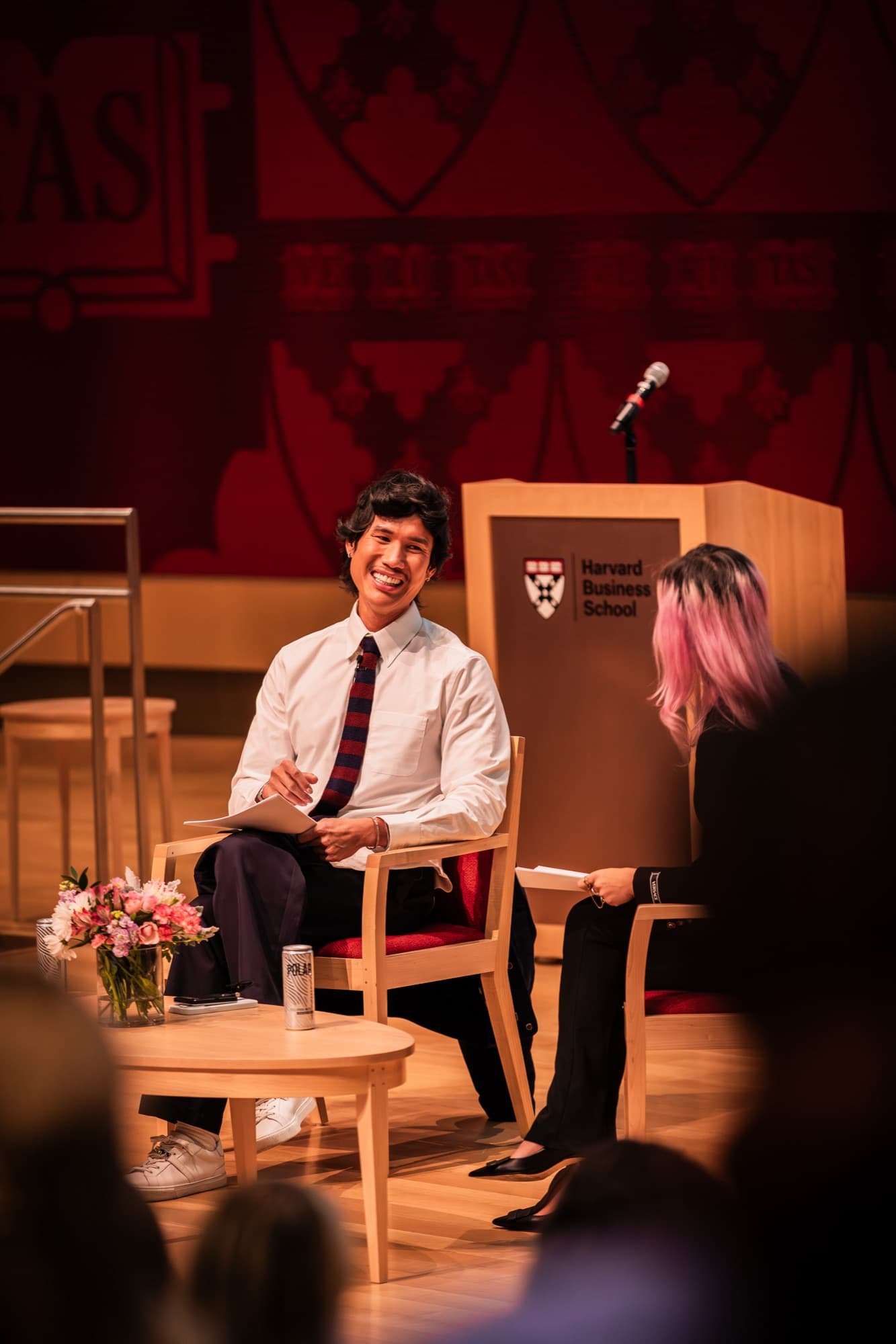 Two speakers laughing during an onstage conversation at Harvard Business School