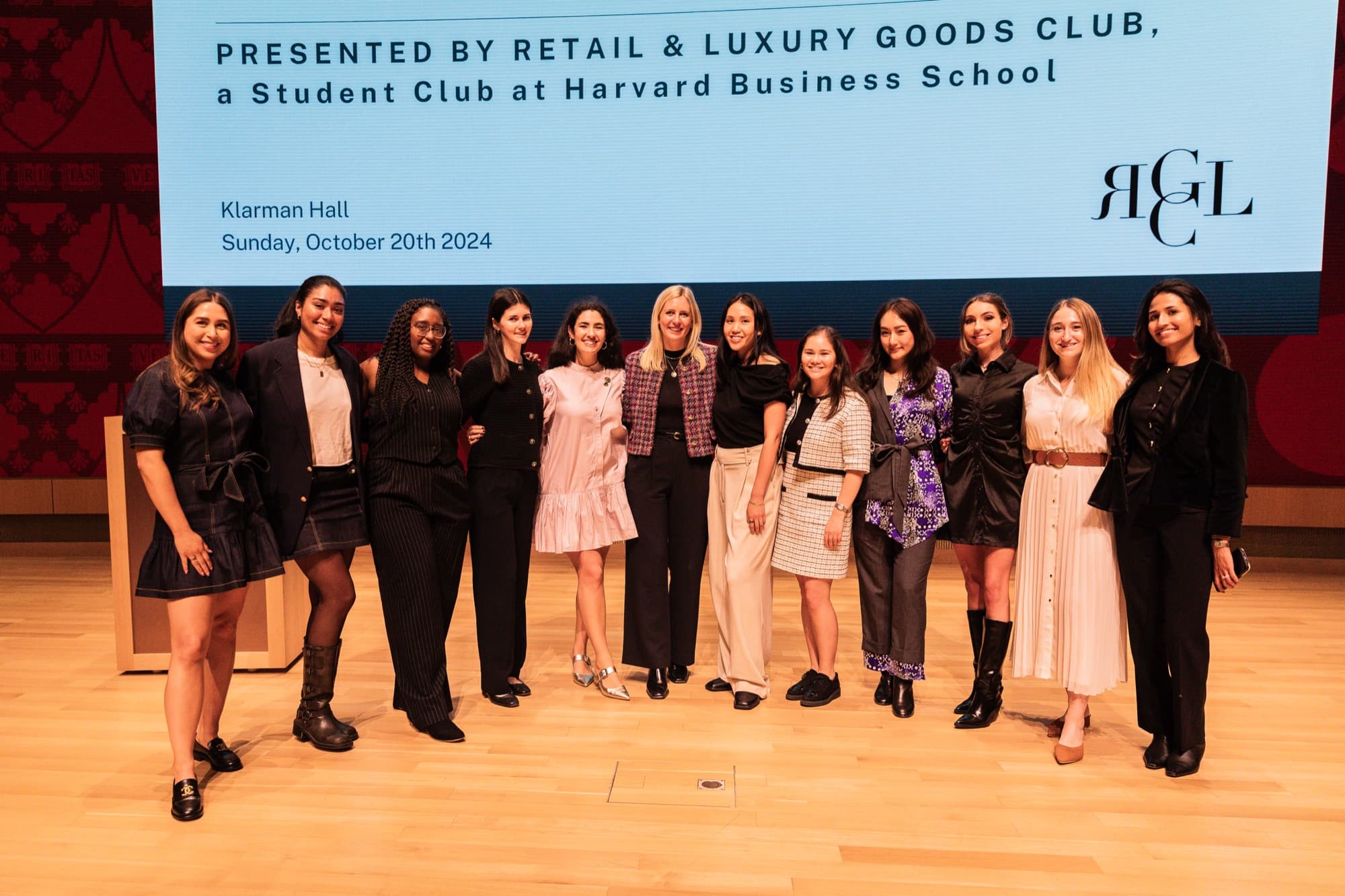 Retail and Luxury Goods Club organizers posing together on an auditorium stage
